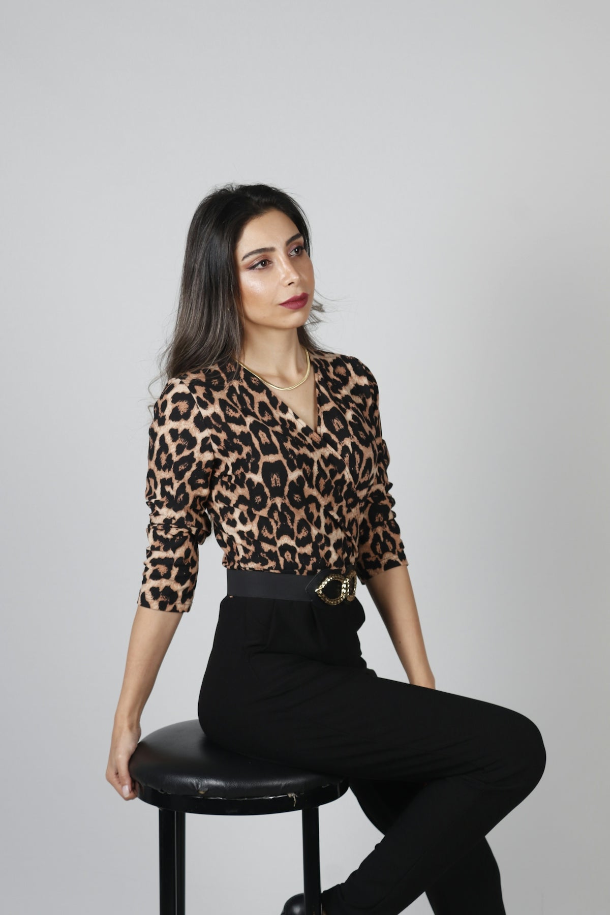 a woman sitting on top of a stool