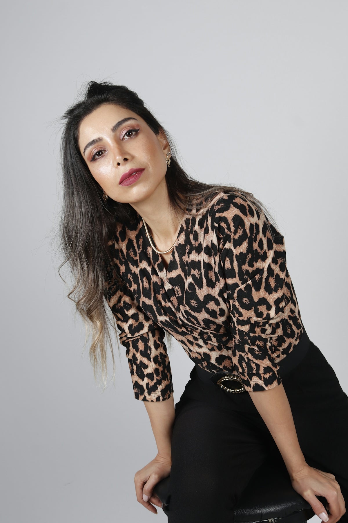 a woman in a leopard print shirt and black pants