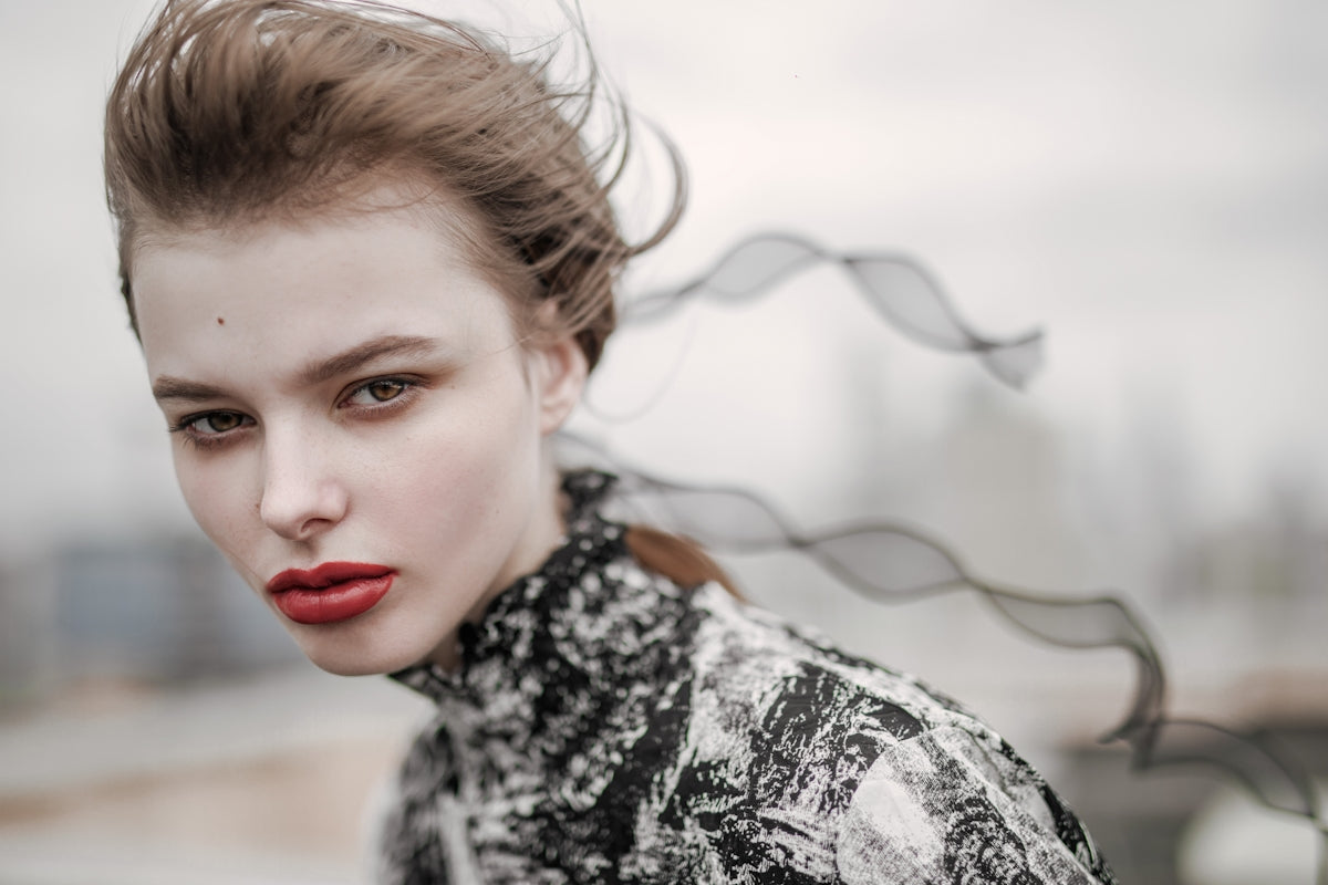 a woman with red lips and a messy topknott