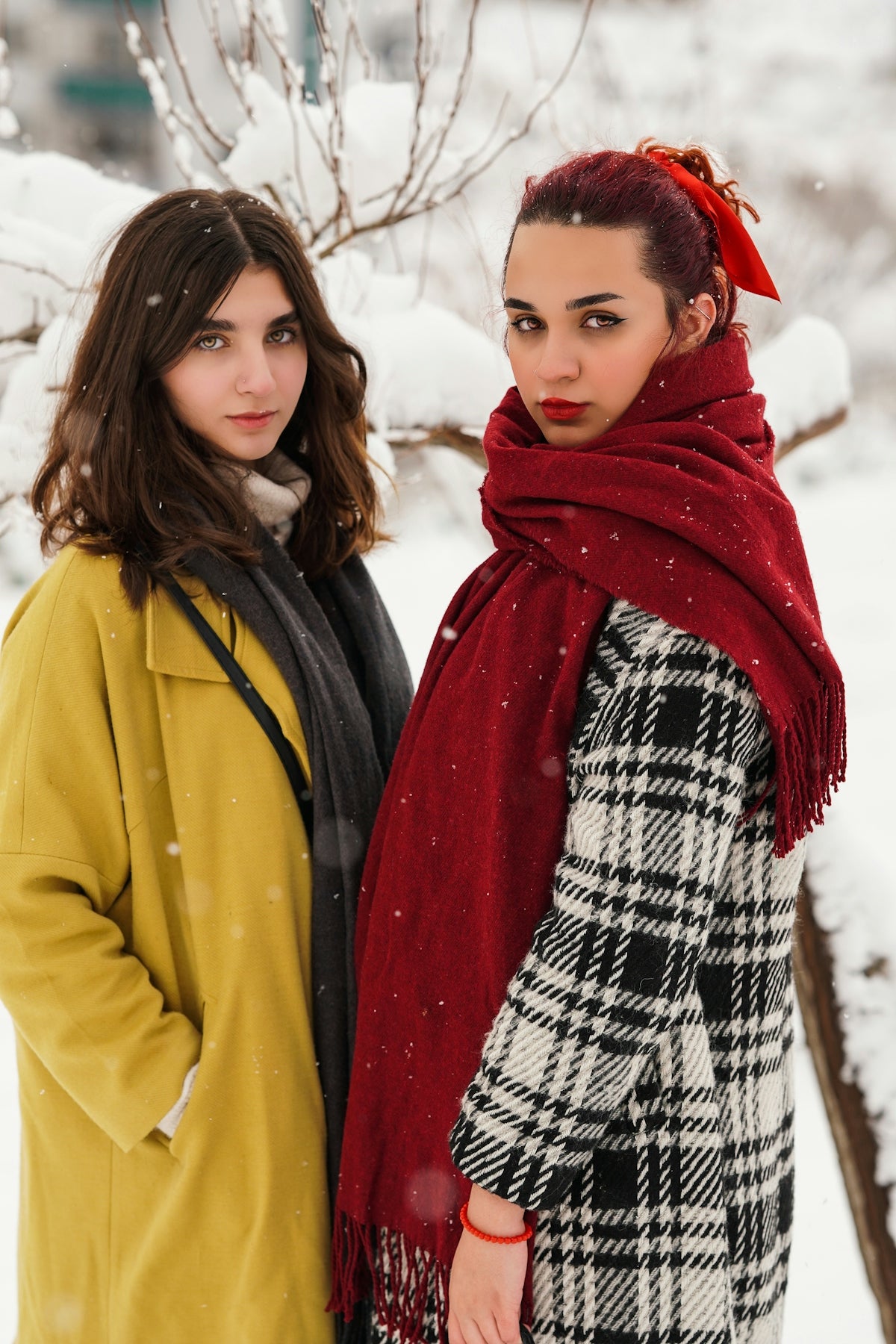 two women standing next to each other in the snow