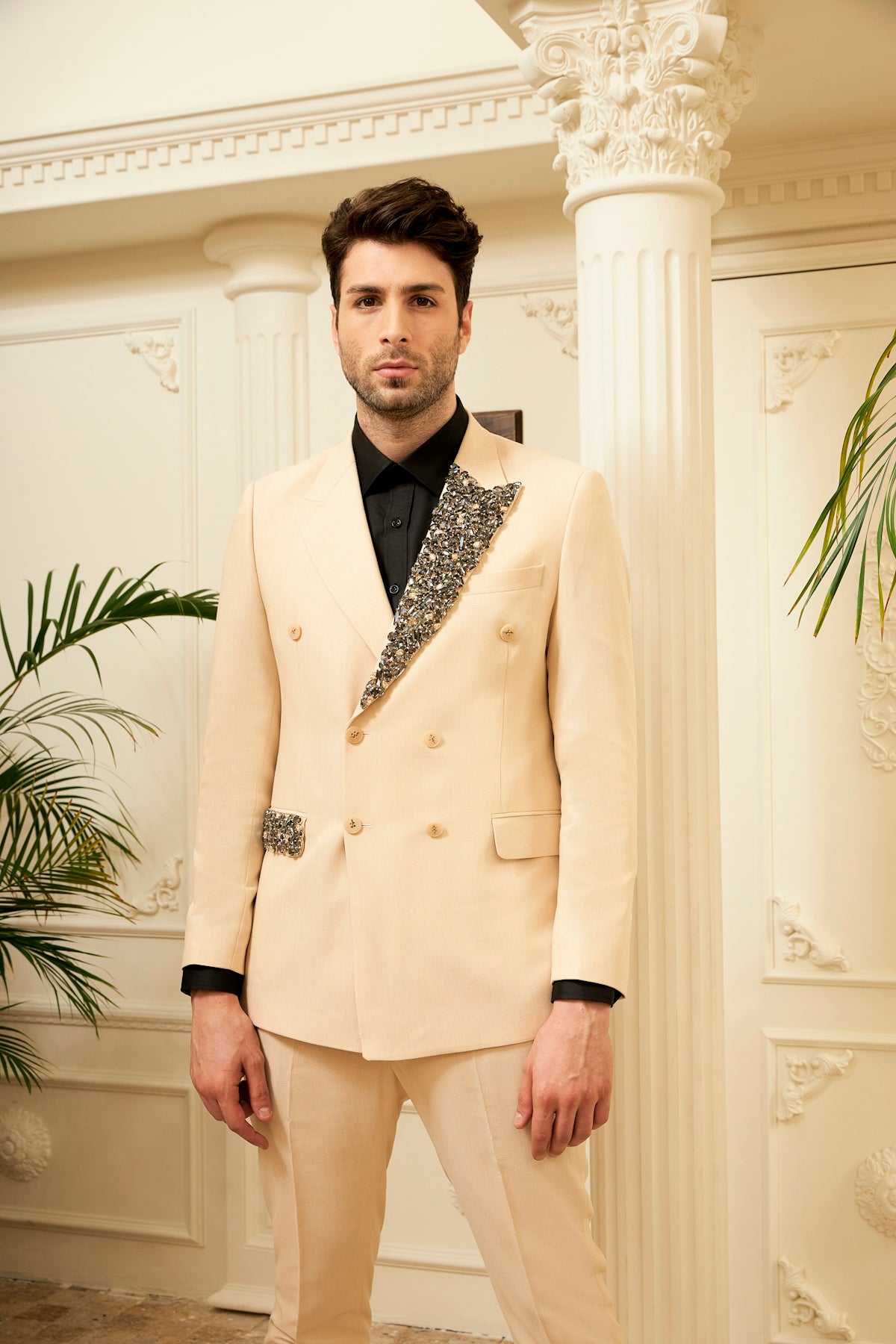 a man in a tuxedo poses for a picture