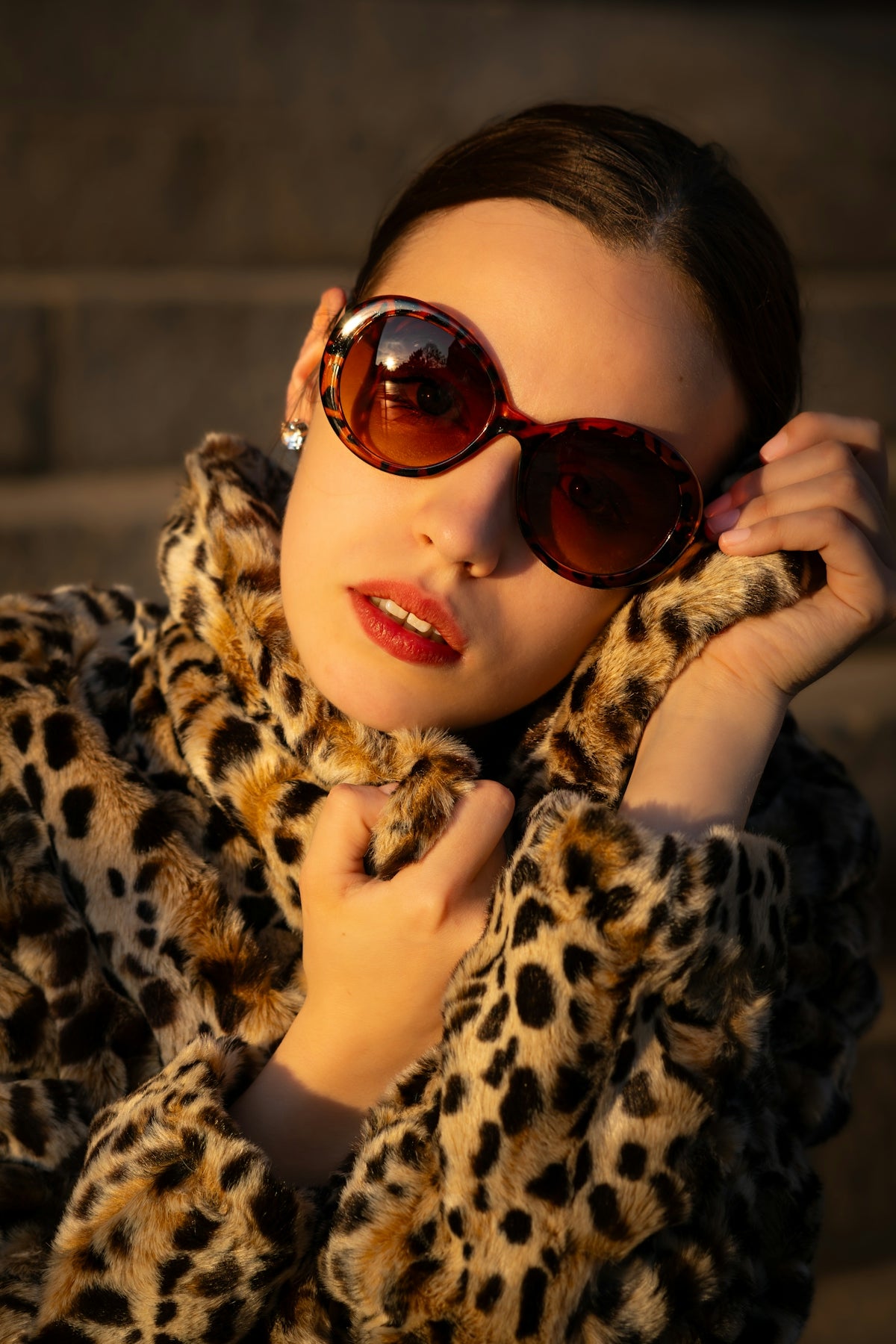 a woman wearing sunglasses and a leopard print coat