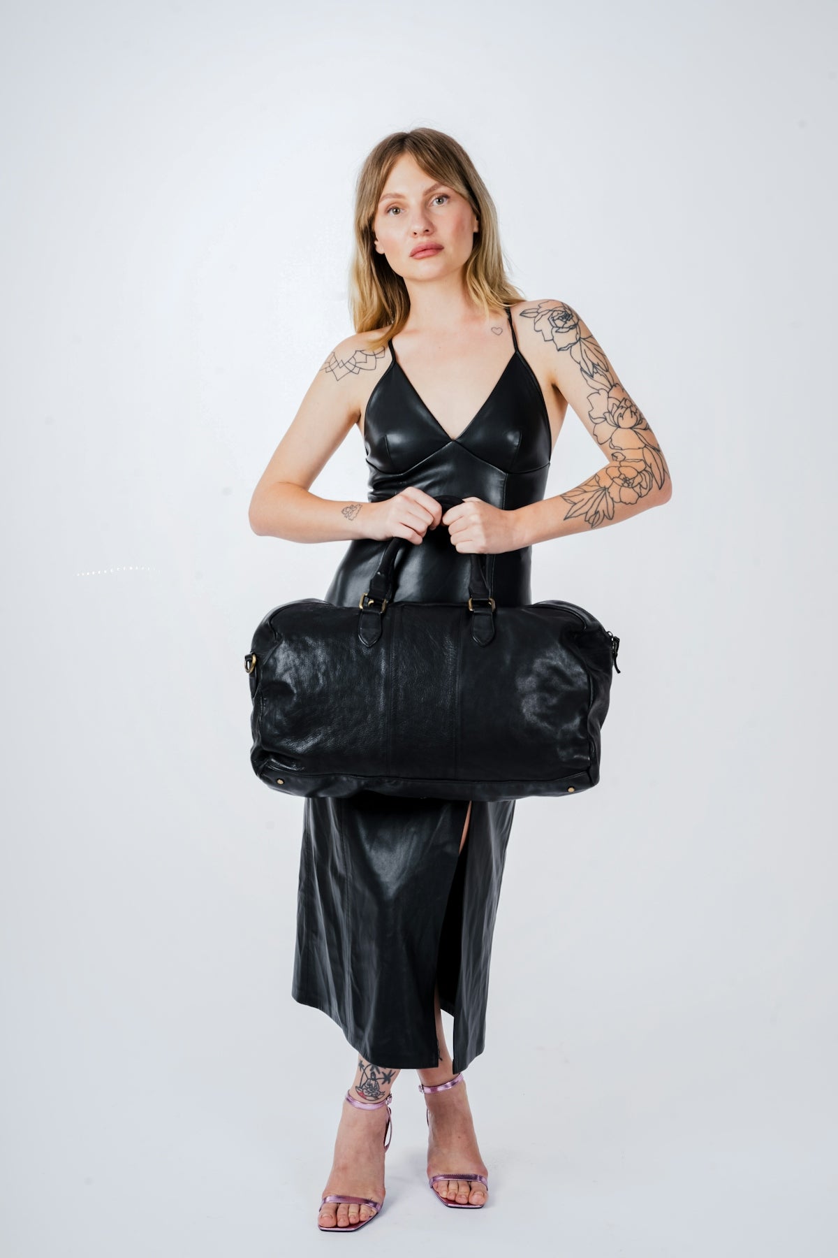 a woman in a black dress holding a black bag
