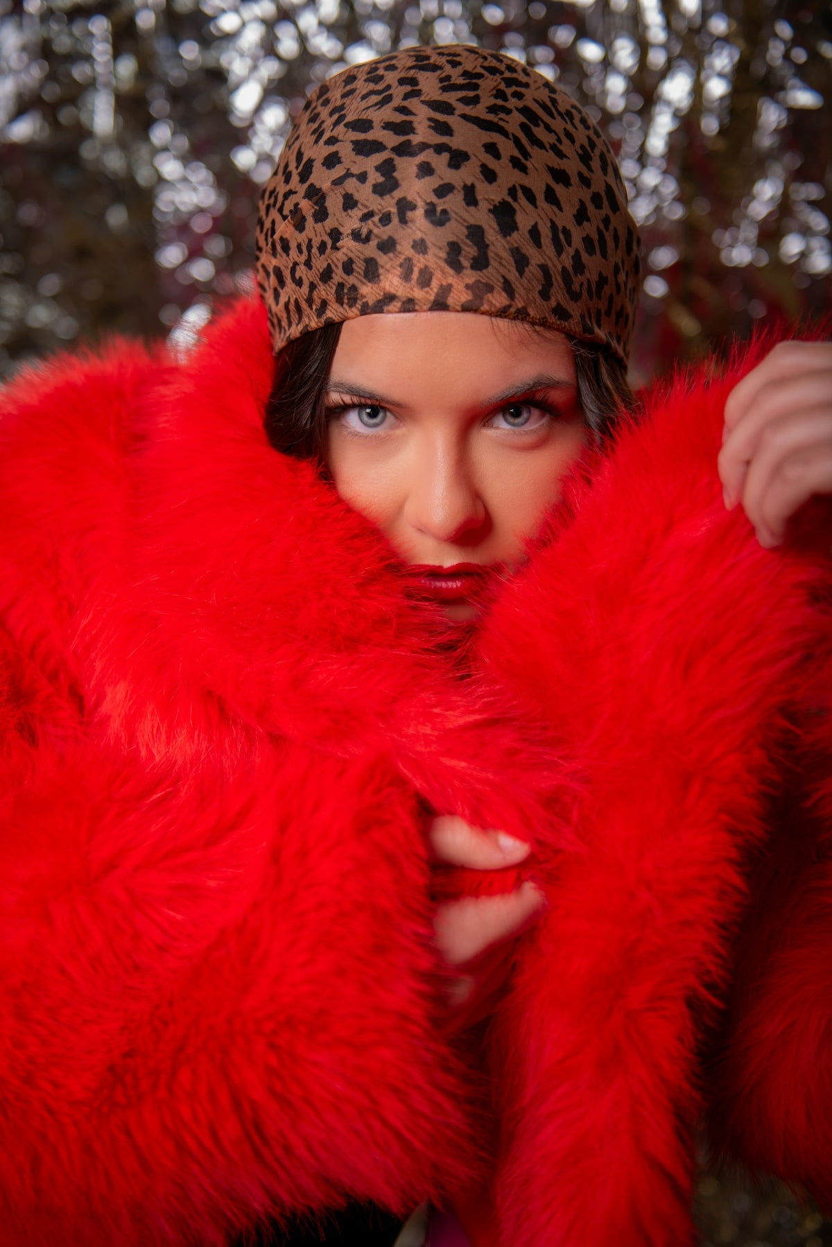 A woman wearing a leopard print hat and a red coat