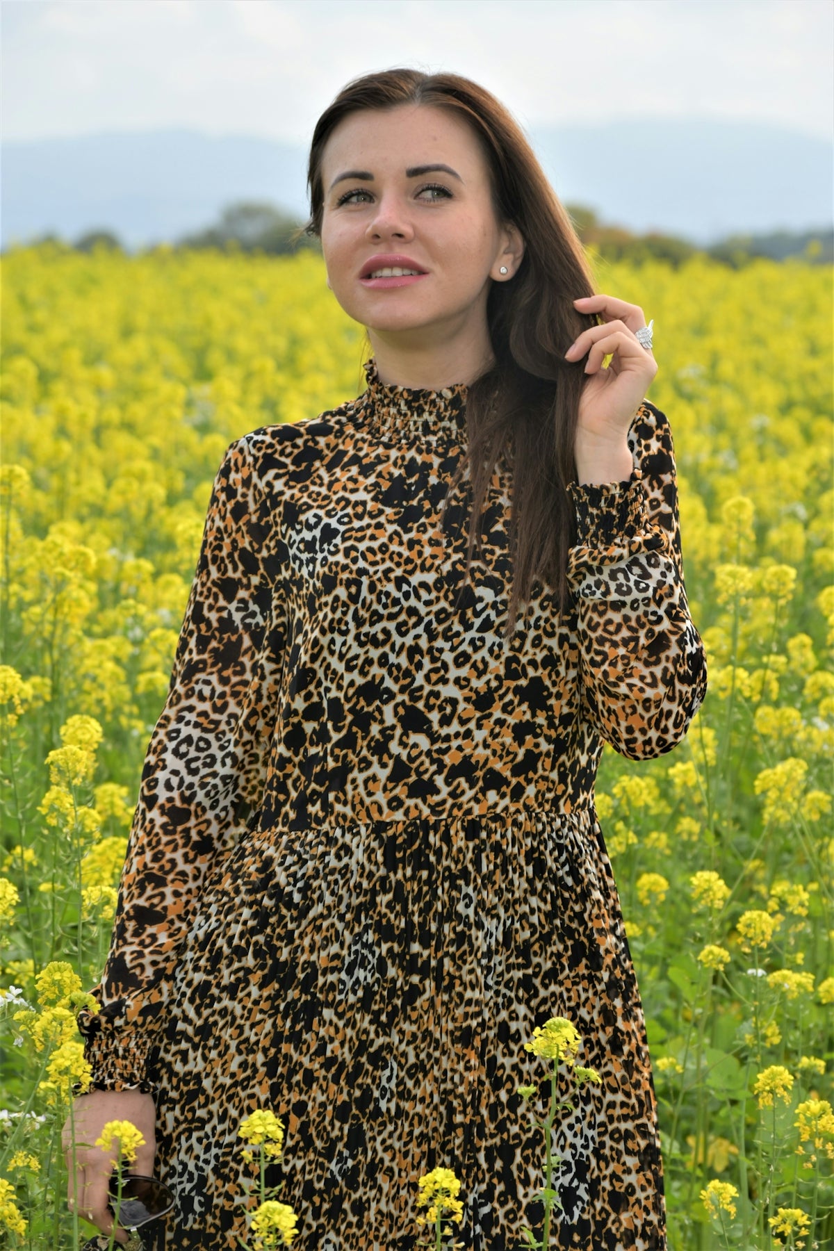 a woman standing in a field of yellow flowers