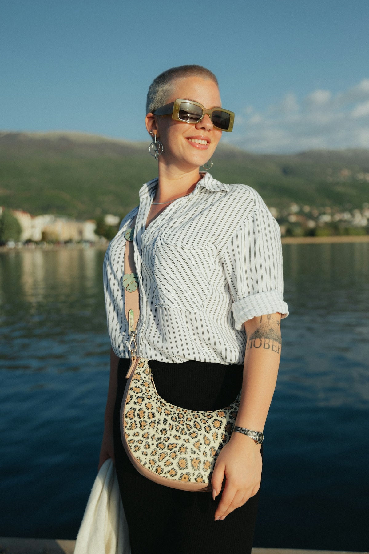 a woman standing on a dock holding a purse